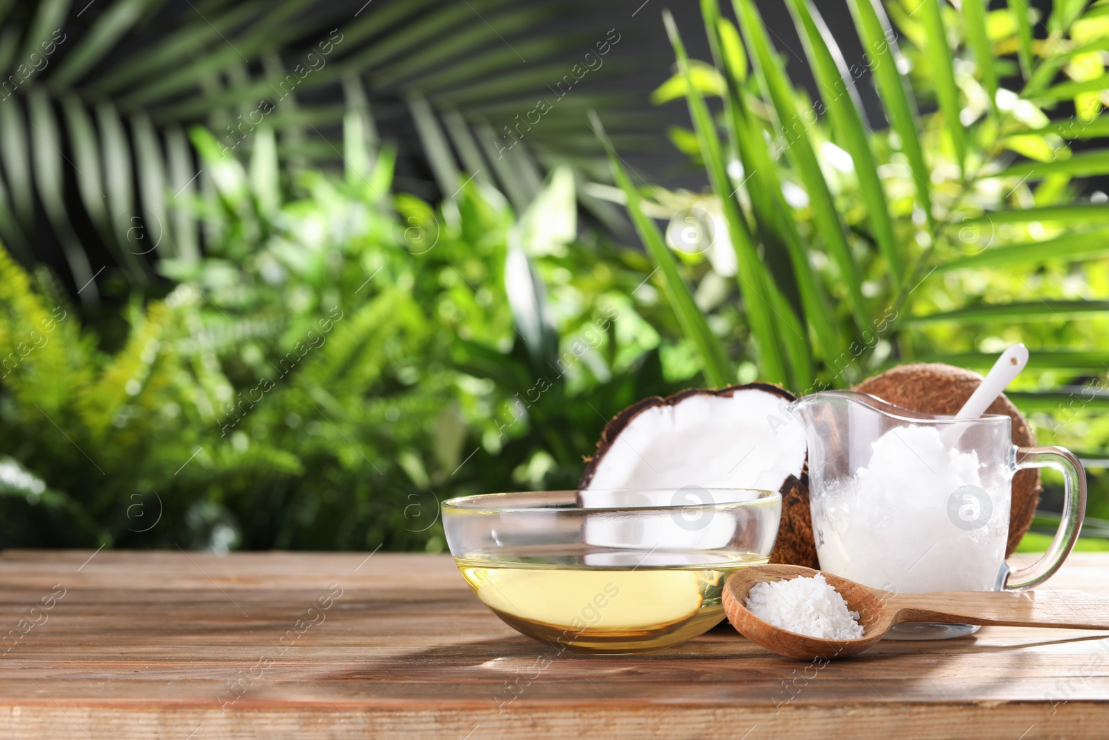 Photo of Composition with natural organic coconut oil on wooden table. Space for text