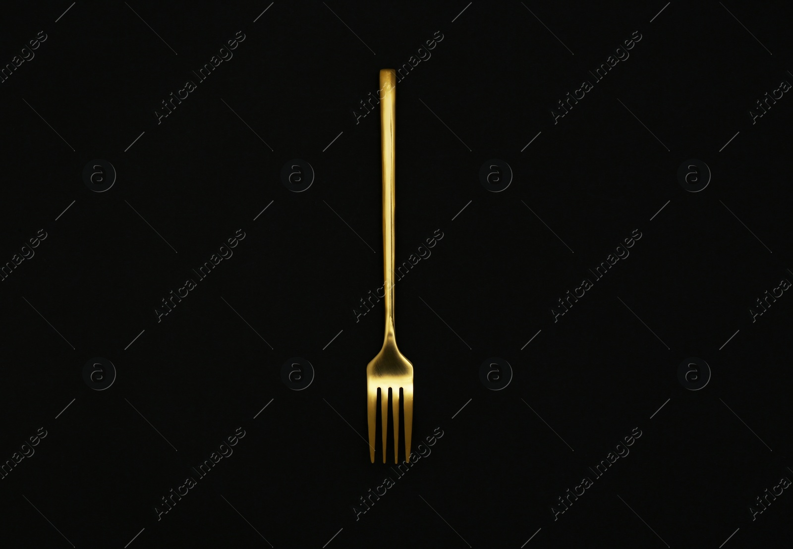 Photo of Shiny gold fork on black background, top view