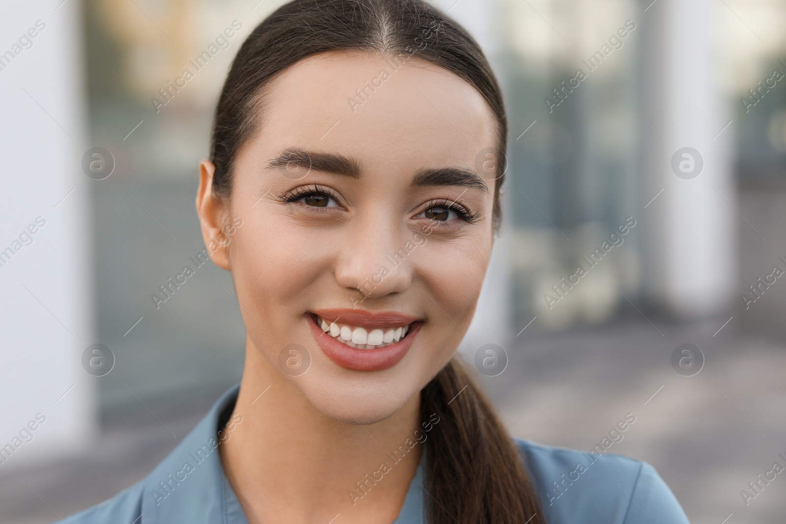 Photo of Portrait of beautiful woman outdoors. Attractive lady smiling and looking into camera