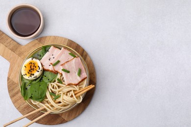 Delicious ramen with meat served on white table, flat lay and space for text. Noodle soup