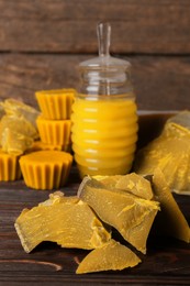 Photo of Different natural beeswax blocks and honey on wooden table