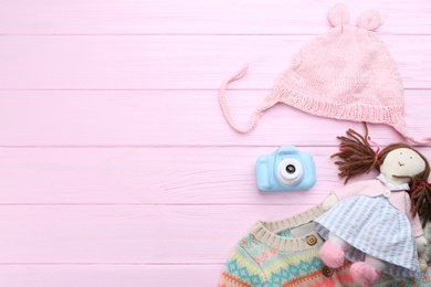 Flat lay composition with little photographer's toy camera on pink wooden background. Space for text