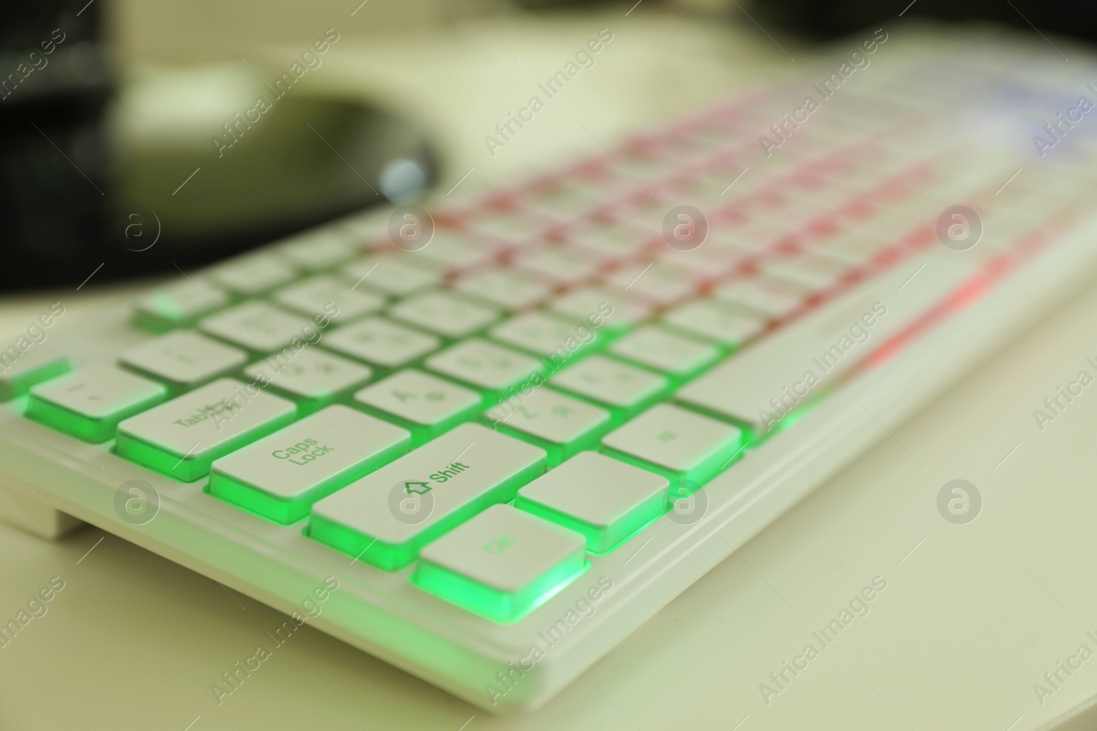 Photo of Modern RGB keyboard on white table indoors, closeup