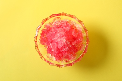 Photo of Shaving ice in glass dessert bowl on yellow  background, top view