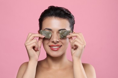 Photo of Woman covering eyes with tea bags on pink background. Skin care