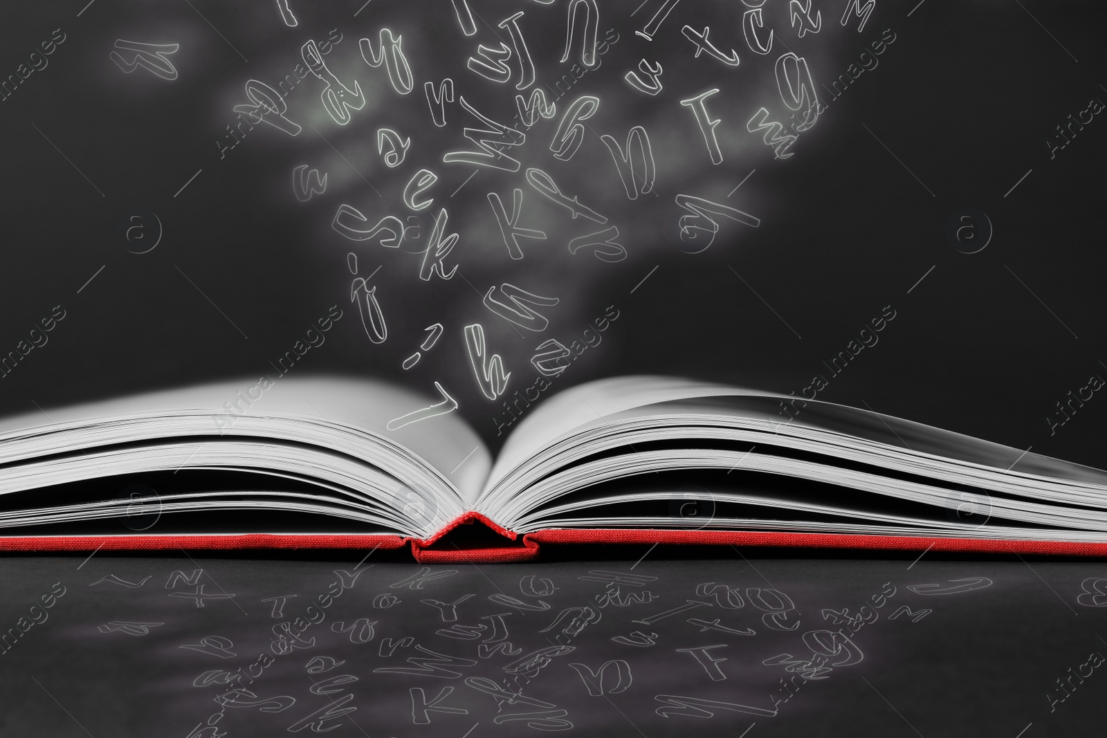 Image of Open book with flying letters on black background. Dyslexia concept