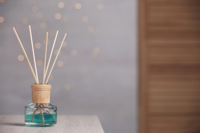 Photo of Aromatic reed air freshener on wooden table. Space for text