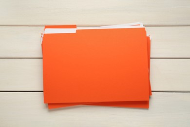 Orange files with documents on white wooden table, top view