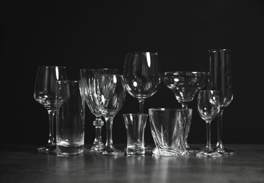 Photo of Set of bar glassware on table against dark background