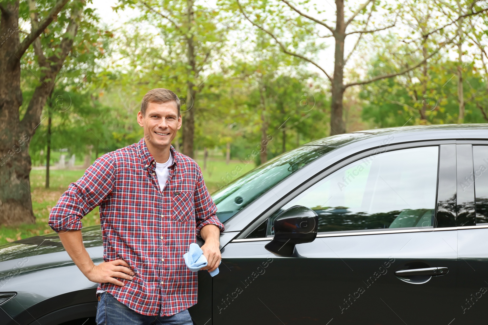 Photo of Man with rug near washed car outdoors