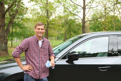 Man with rug near washed car outdoors