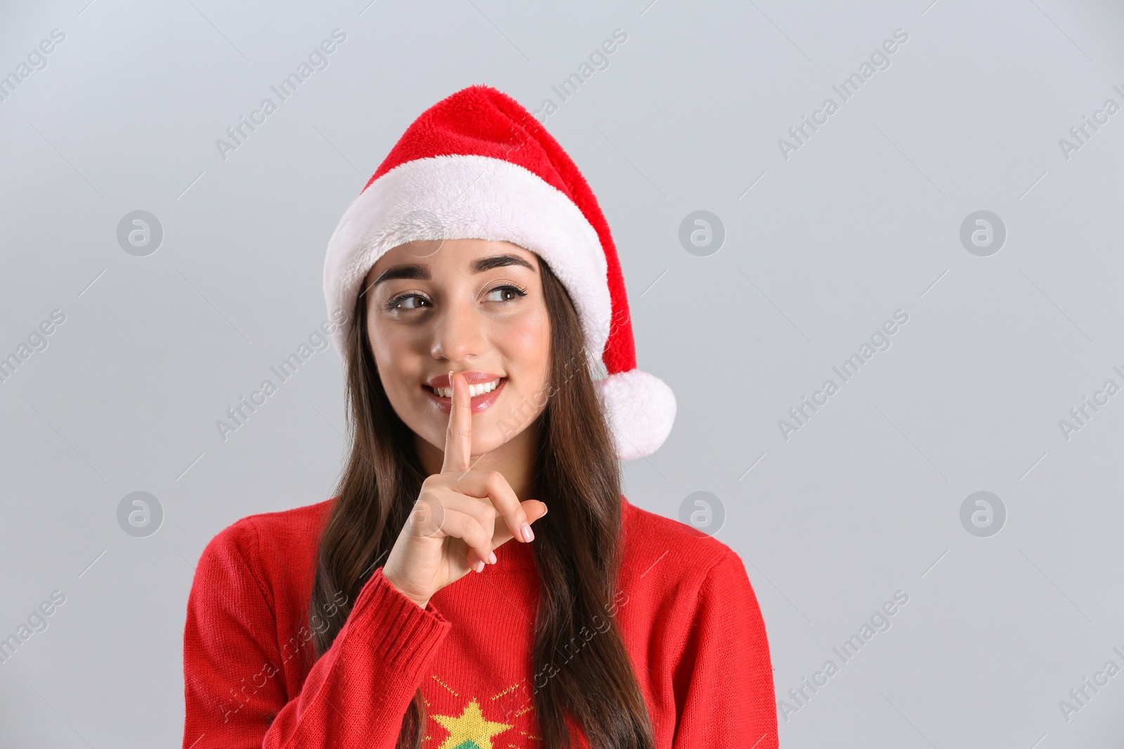 Photo of Beautiful woman wearing Santa Claus hat on light grey background