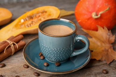 Cup with tasty pumpkin spice latte on wooden table