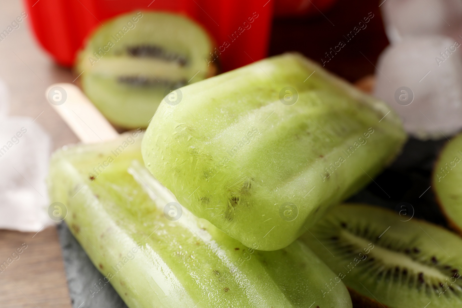 Photo of Tasty kiwi ice pops on table, closeup. Fruit popsicle