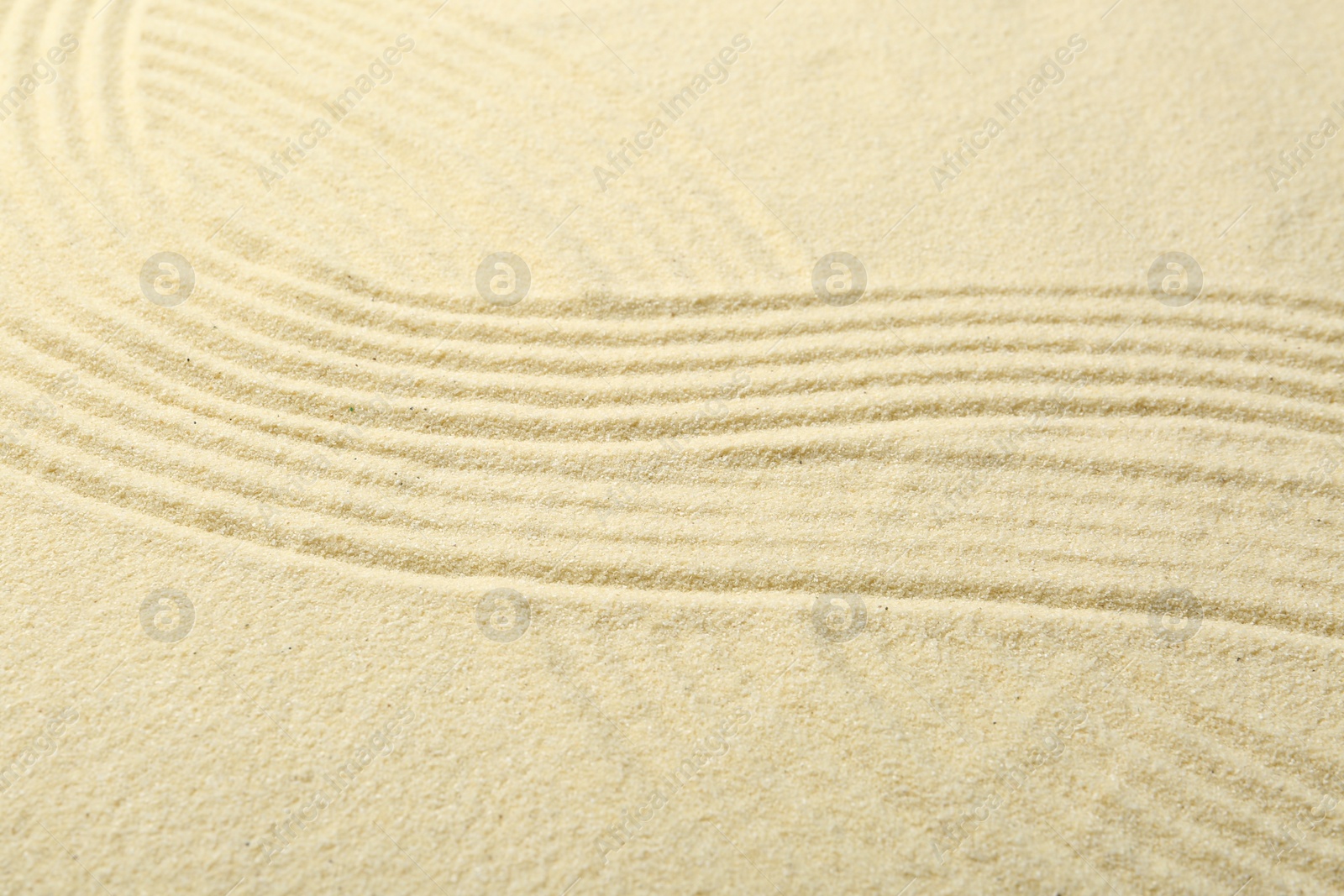 Photo of Zen rock garden. Wave pattern on beige sand