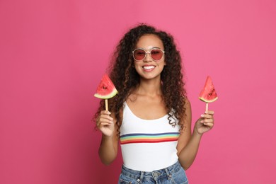 Photo of Beautiful young African American woman with pieces of watermelon on crimson background