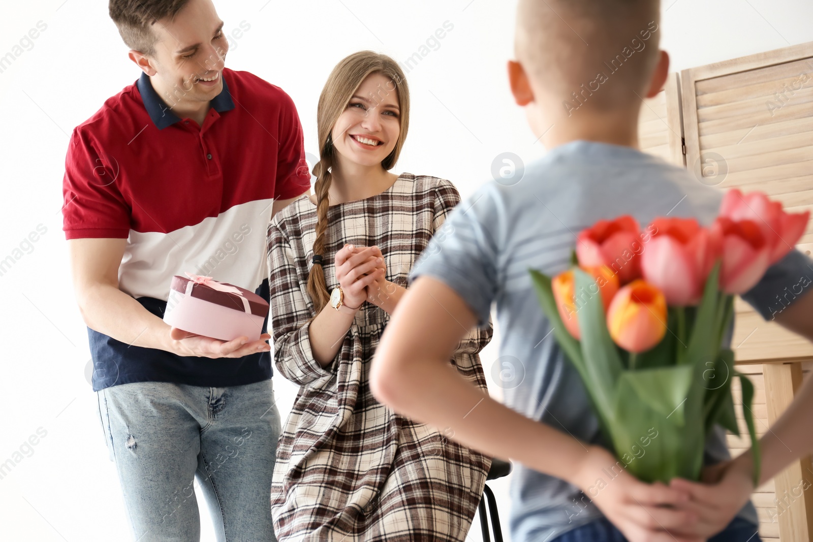 Photo of Happy family celebrating Mother's Day with flowers and gift