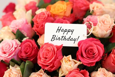 Image of Bouquet of beautiful roses with Happy Birthday card, closeup