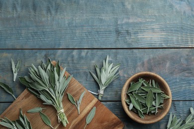 Photo of Fresh green sage with board and bowl on light blue wooden table, flat lay. Space for text