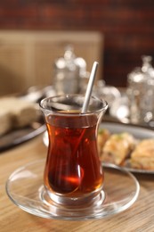 Photo of Traditional Turkish tea in glass on wooden table