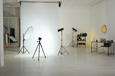 Photo studio interior with set of professional equipment and workplace