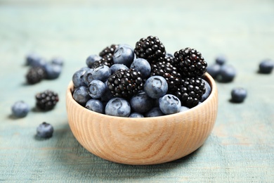 Photo of Blueberries and blackberries on blue wooden table