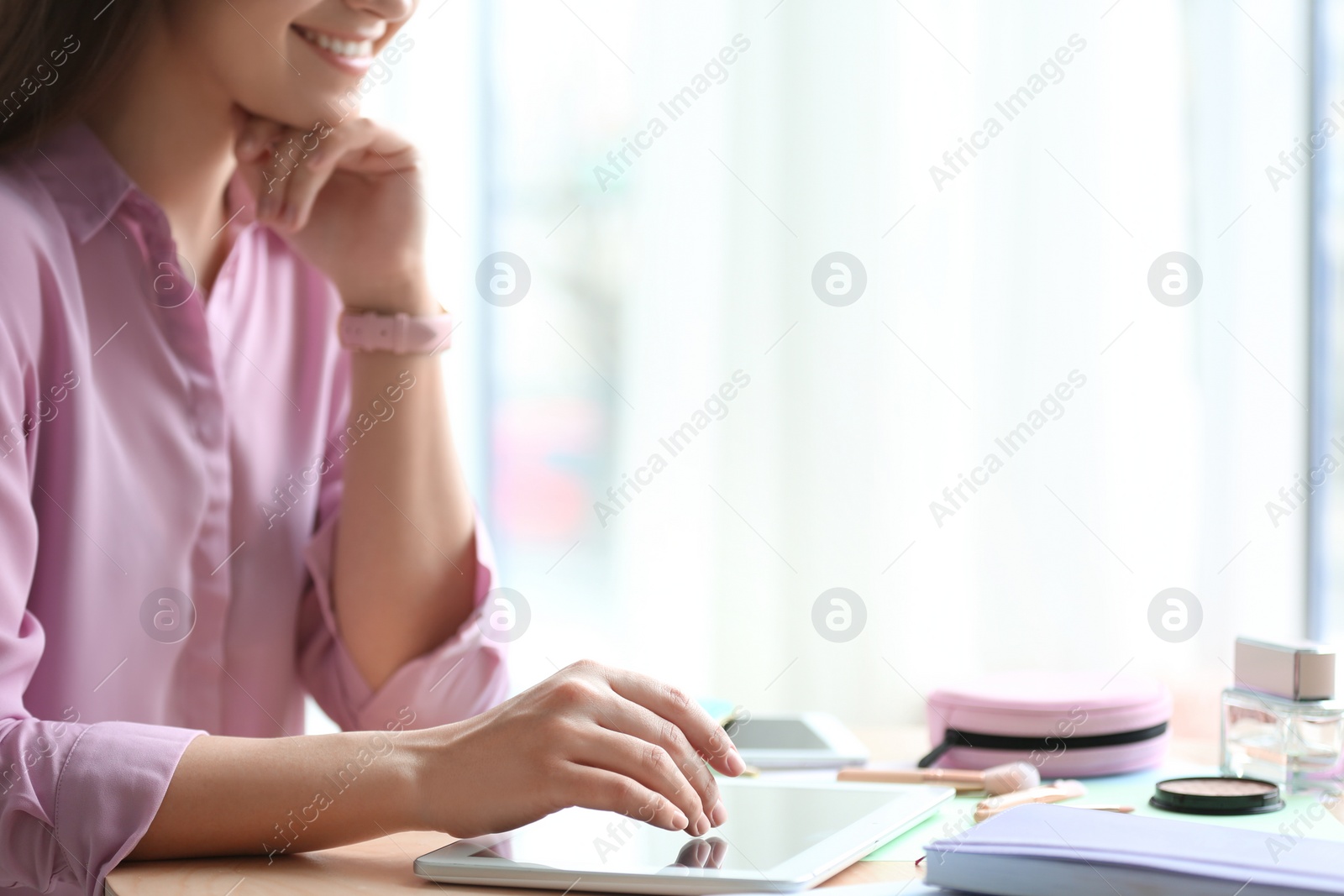 Photo of Female blogger using tablet at table indoors