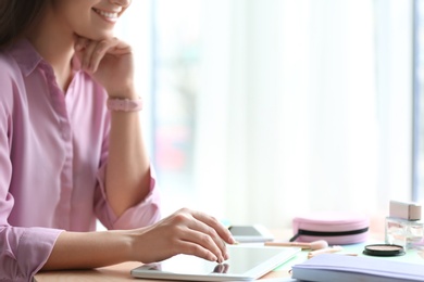 Photo of Female blogger using tablet at table indoors