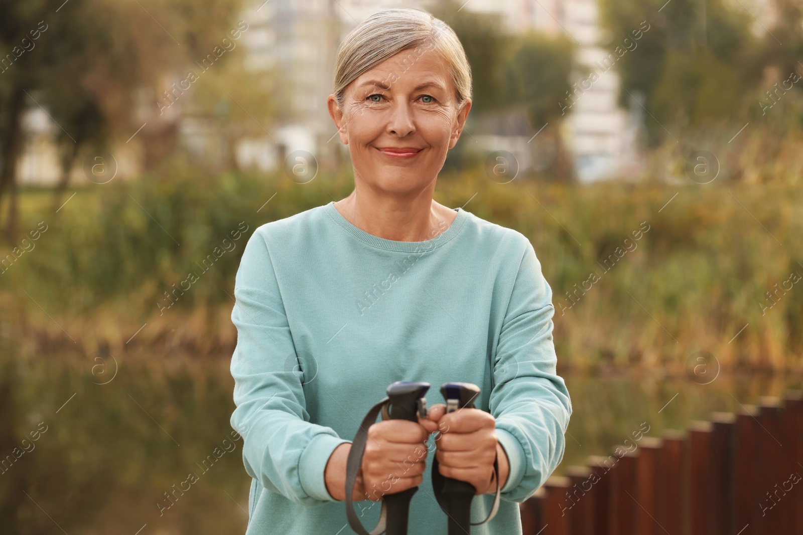 Photo of Senior woman with Nordic walking poles outdoors