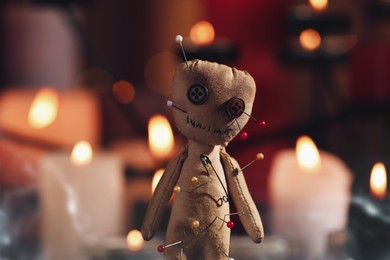 Photo of Voodoo doll pierced with pins in dark room, closeup. Curse ceremony