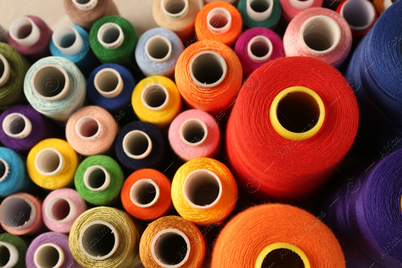 Photo of Set of color sewing threads as background, top view