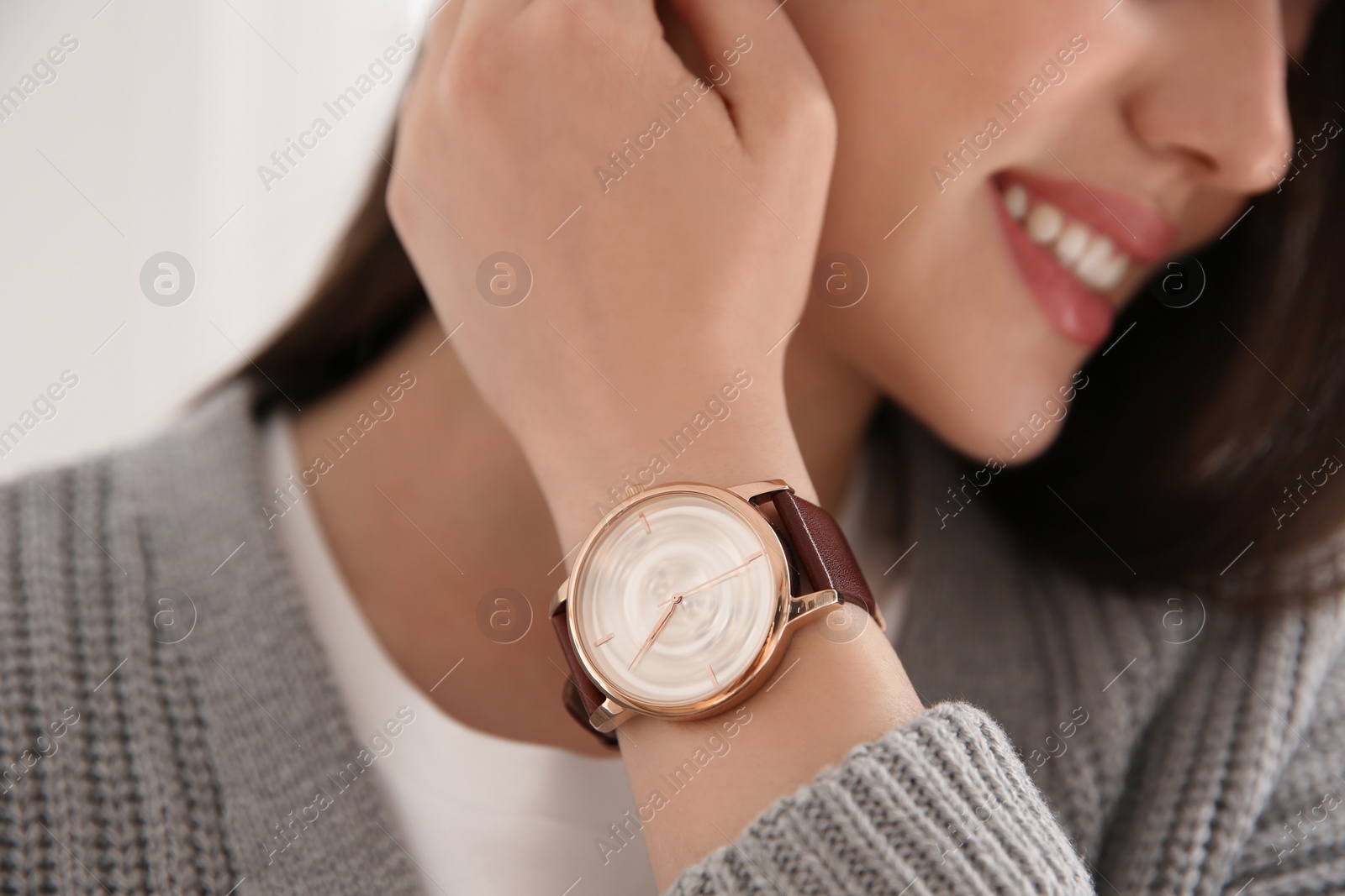 Photo of Woman with luxury wristwatch on light background, closeup