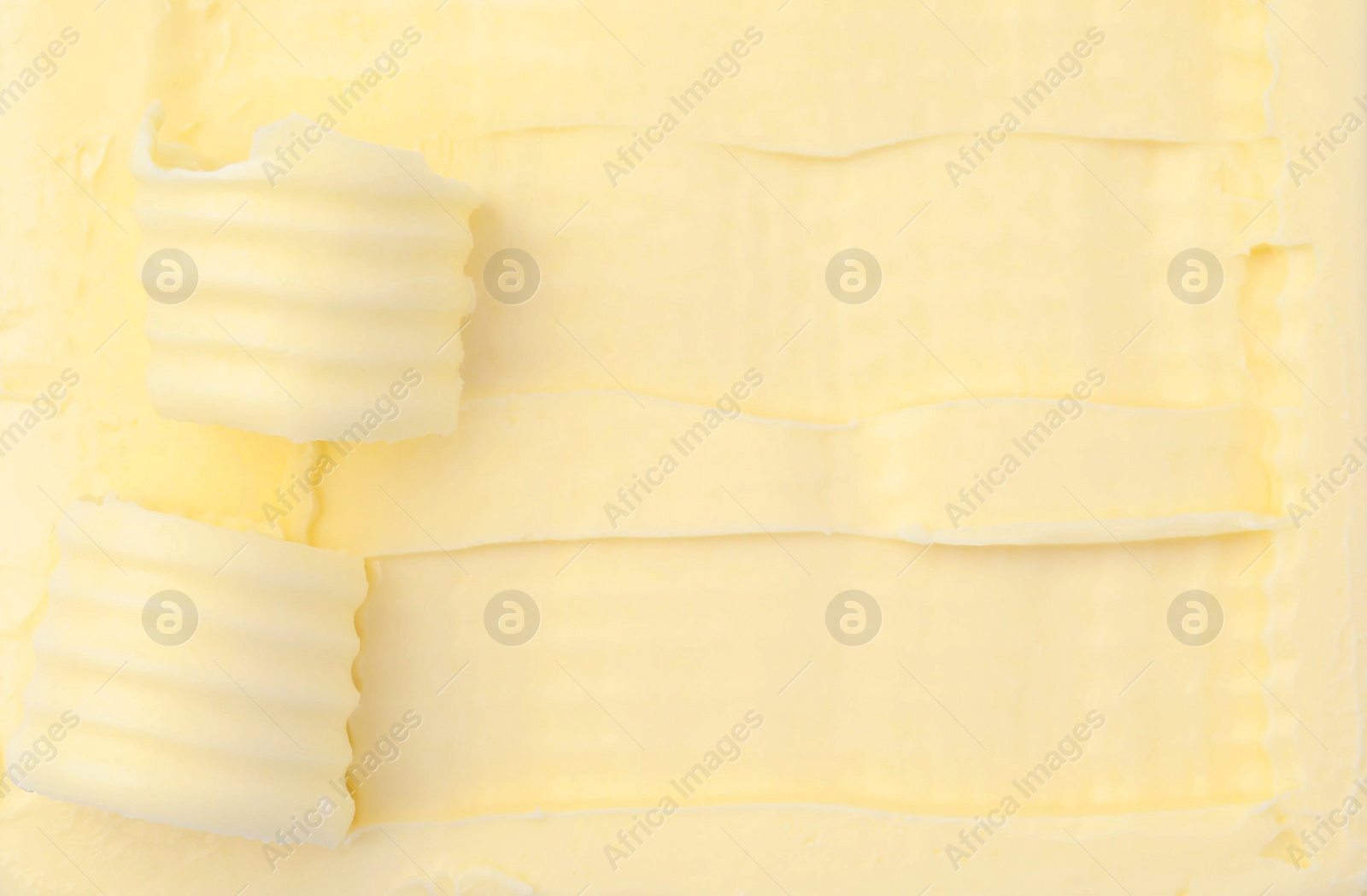 Photo of Tasty butter and curls as background, top view