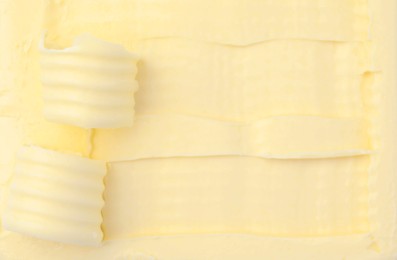Photo of Tasty butter and curls as background, top view