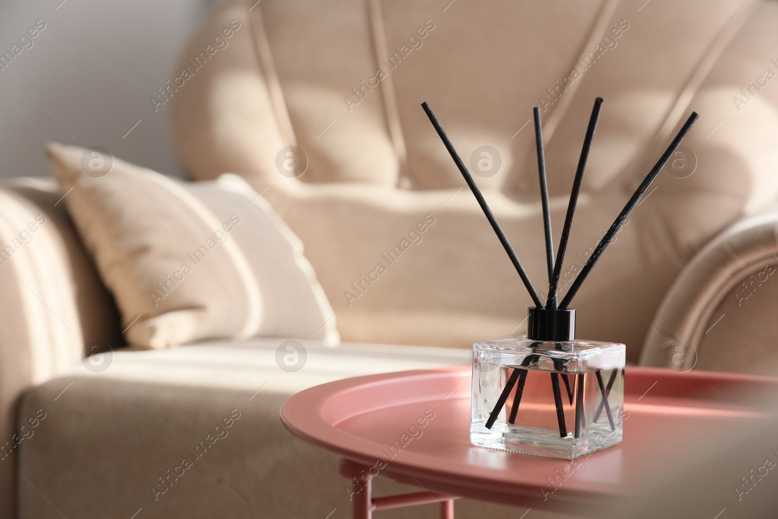 Photo of Aromatic reed air freshener on table indoors, space for text