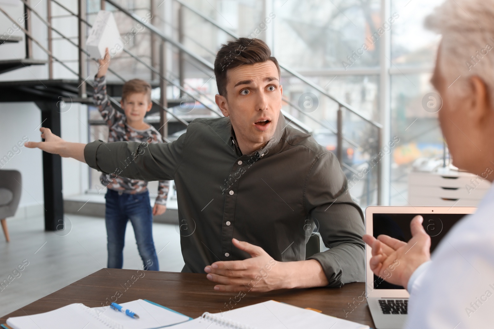 Photo of Young man complaining about mischievous son at child psychologist office