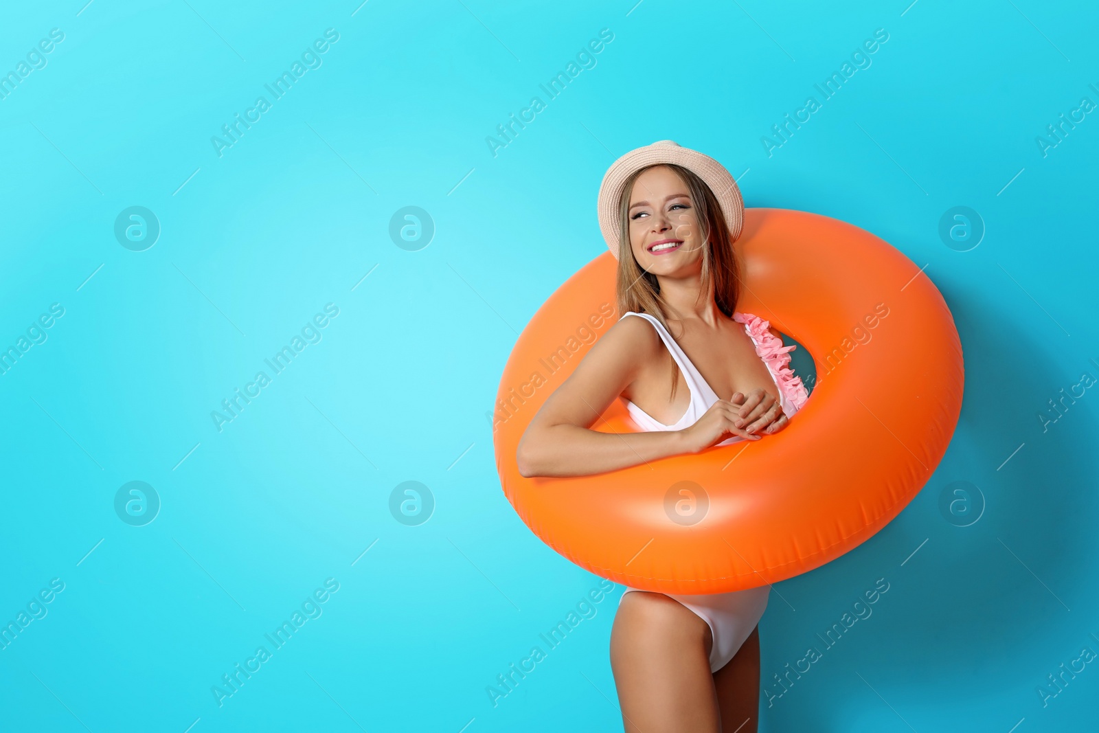 Photo of Sexy young woman in bikini with inflatable ring on color background