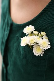 Photo of Woman wearing shirt with flowers in pocket, closeup