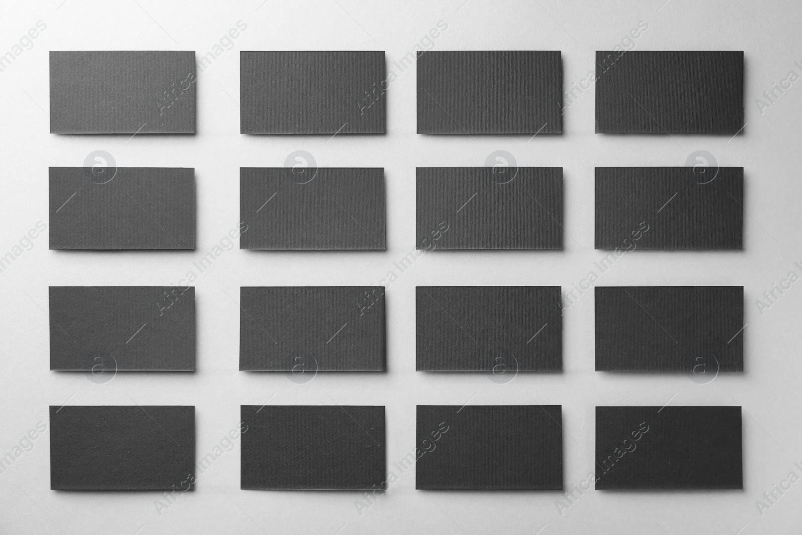 Photo of Blank black business cards on light background, flat lay. Mockup for design