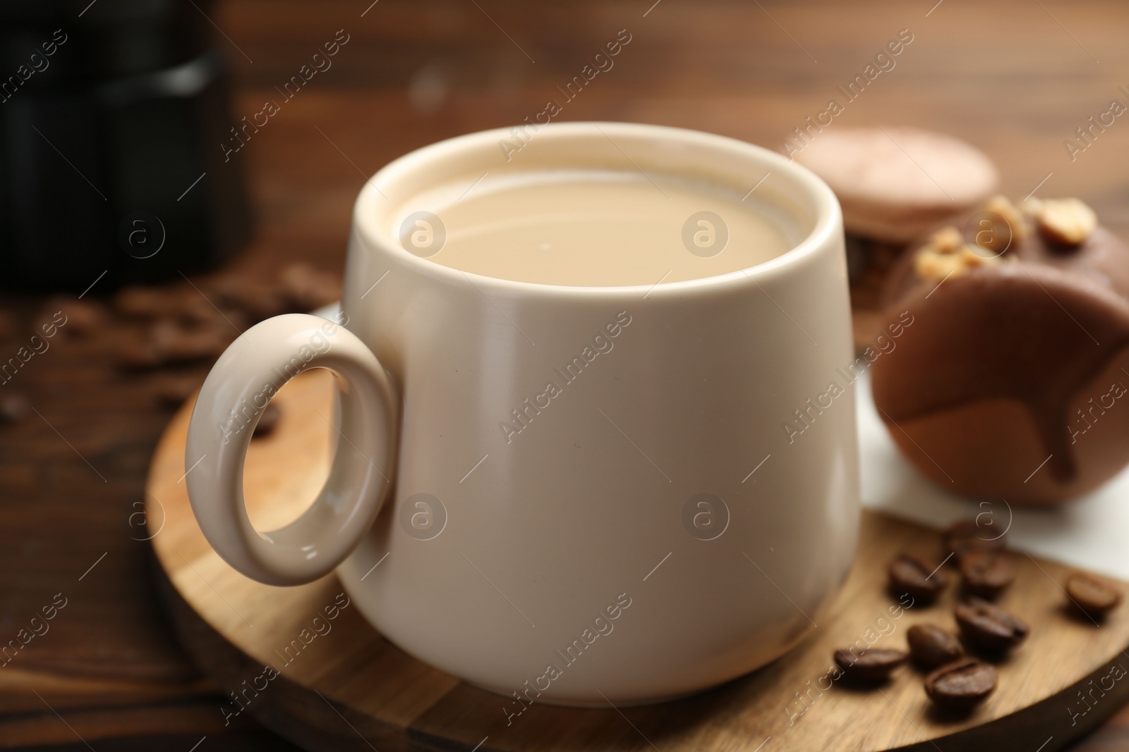 Photo of Cup of coffee and delicious macarons on wooden table, closeup
