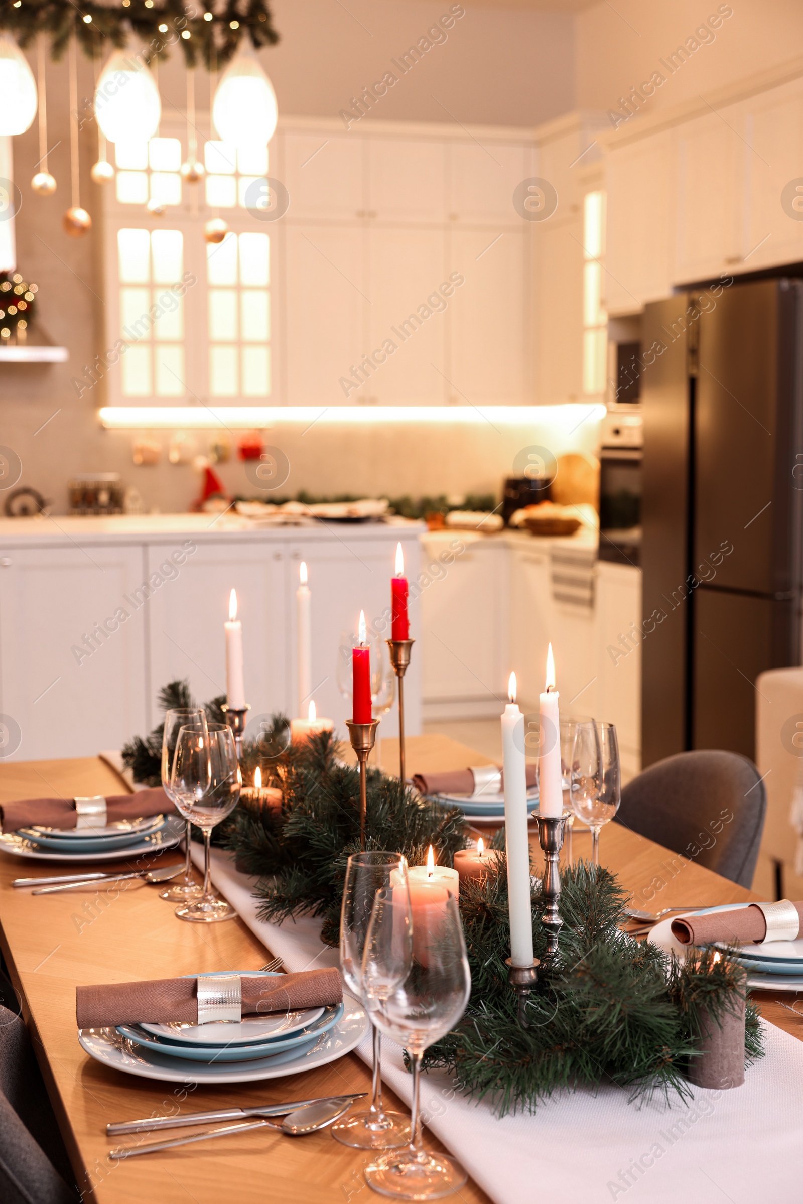 Photo of Festive table setting and beautiful Christmas decor in kitchen. Interior design