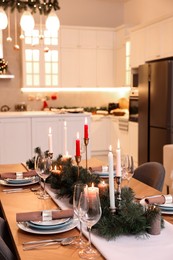 Photo of Festive table setting and beautiful Christmas decor in kitchen. Interior design