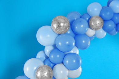 Image of Balloon garland on light blue background. Festive decor