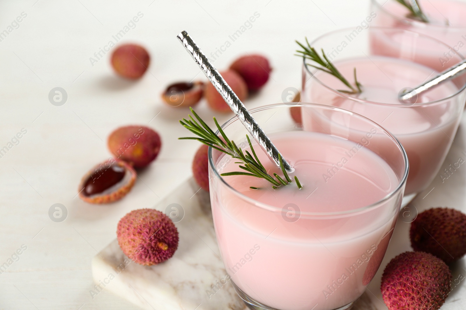 Photo of Lychee cocktail with rosemary white table, closeup