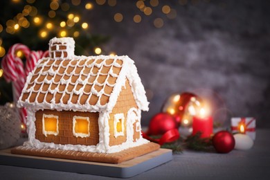 Image of Beautiful gingerbread house decorated with icing on grey wooden table