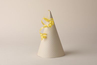 One beautiful party hat with serpentine streamer on beige background