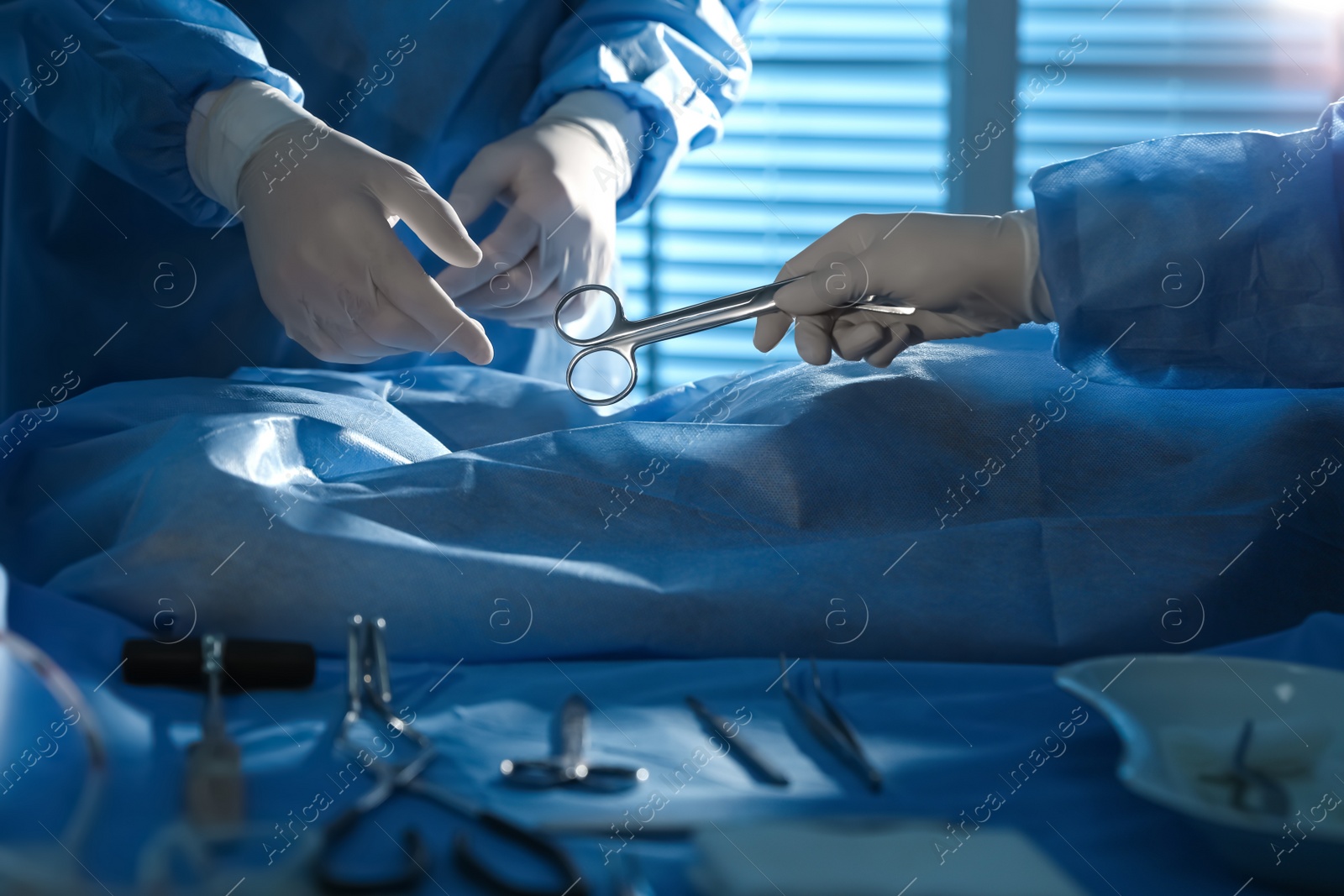 Photo of Professional surgeons with instruments performing operation in clinic, closeup