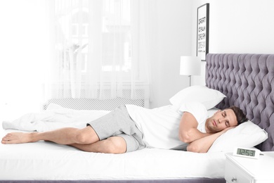 Young man sleeping in bed at home