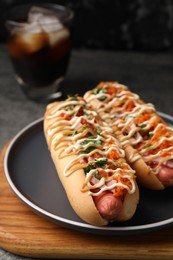 Photo of Delicious hot dogs with bacon, carrot and parsley on table, closeup