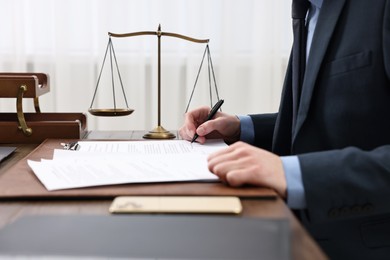 Lawyer working with documents at table indoors, closeup